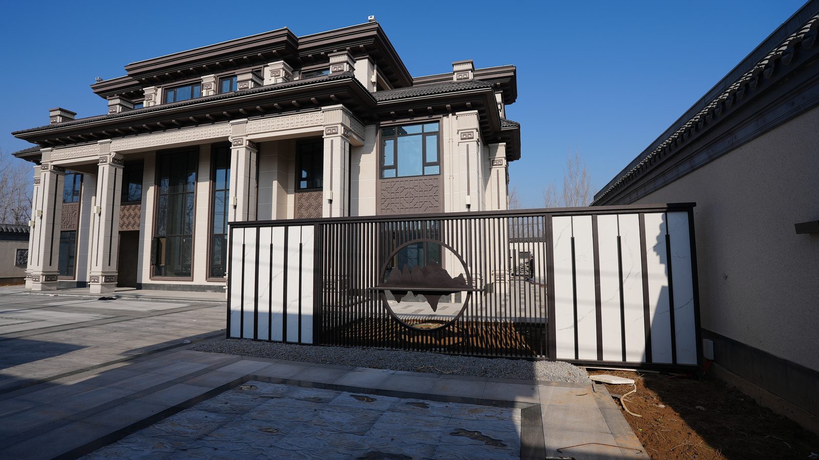 新中式二层别墅完工：奶白色外墙配深棕色线条与铁艺山水院门