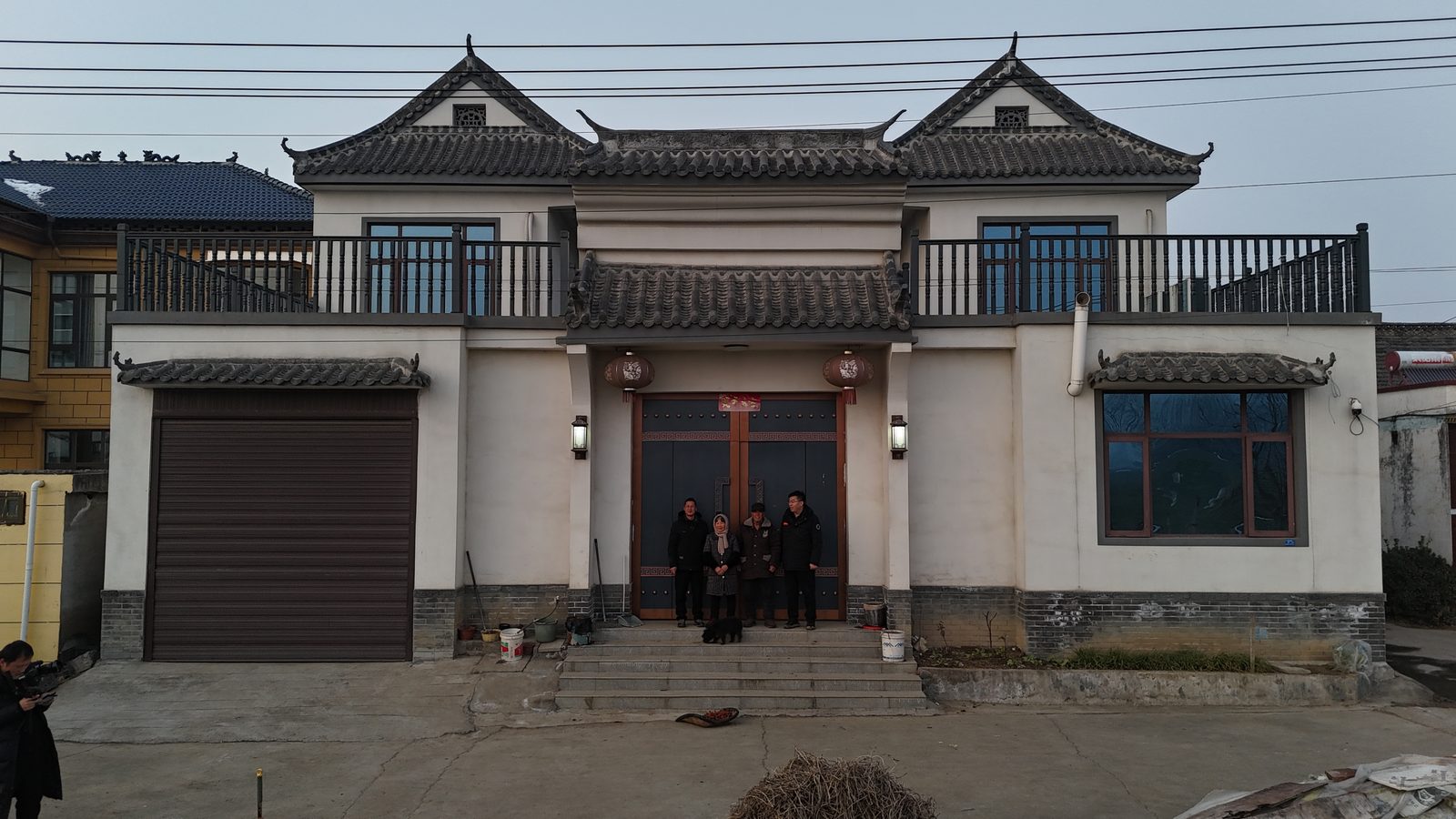 徽派合院白墙黛瓦完工，一家四口在门口与小狗合影
